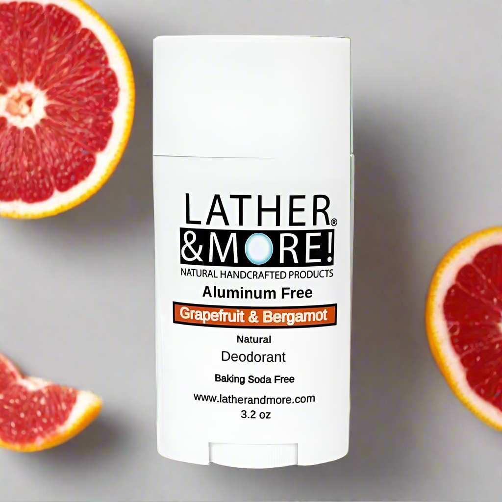 Grapefruit & Bergamot Natural Deodorant - White deodorant tube babels Lather and More Aluminum Free and Baking soda free natural deodorant with branding logo and product name encased in a orange border on a grey background. surrounded by sliced grapefruit.