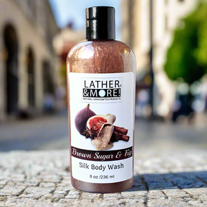 Brown sugar and fig silk body wash sitting on cobblestone outside 