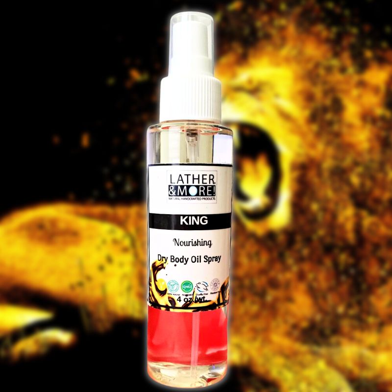 A spray bottle of KING Dry Body Oil with a yellow label, set against a textured yellow background.