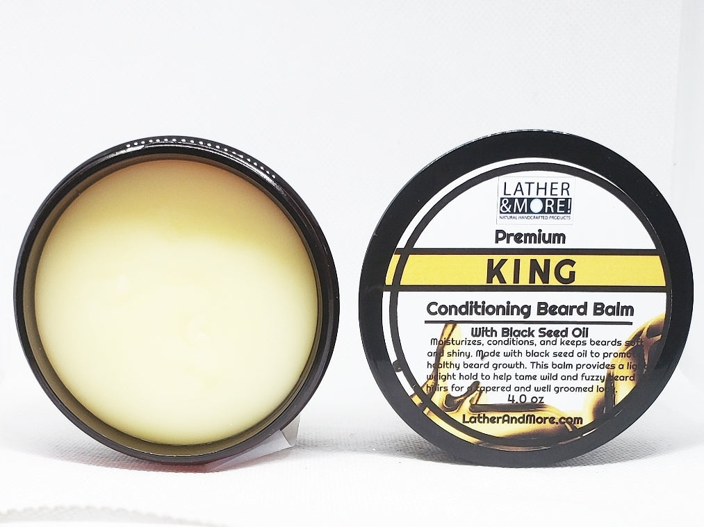 An open jar of KING Conditioning Beard Balm by Lather and Lace with a clear view of the balm inside. The label on the jar is visible and reads 'KING' in bold, indicating the brand or product name.
