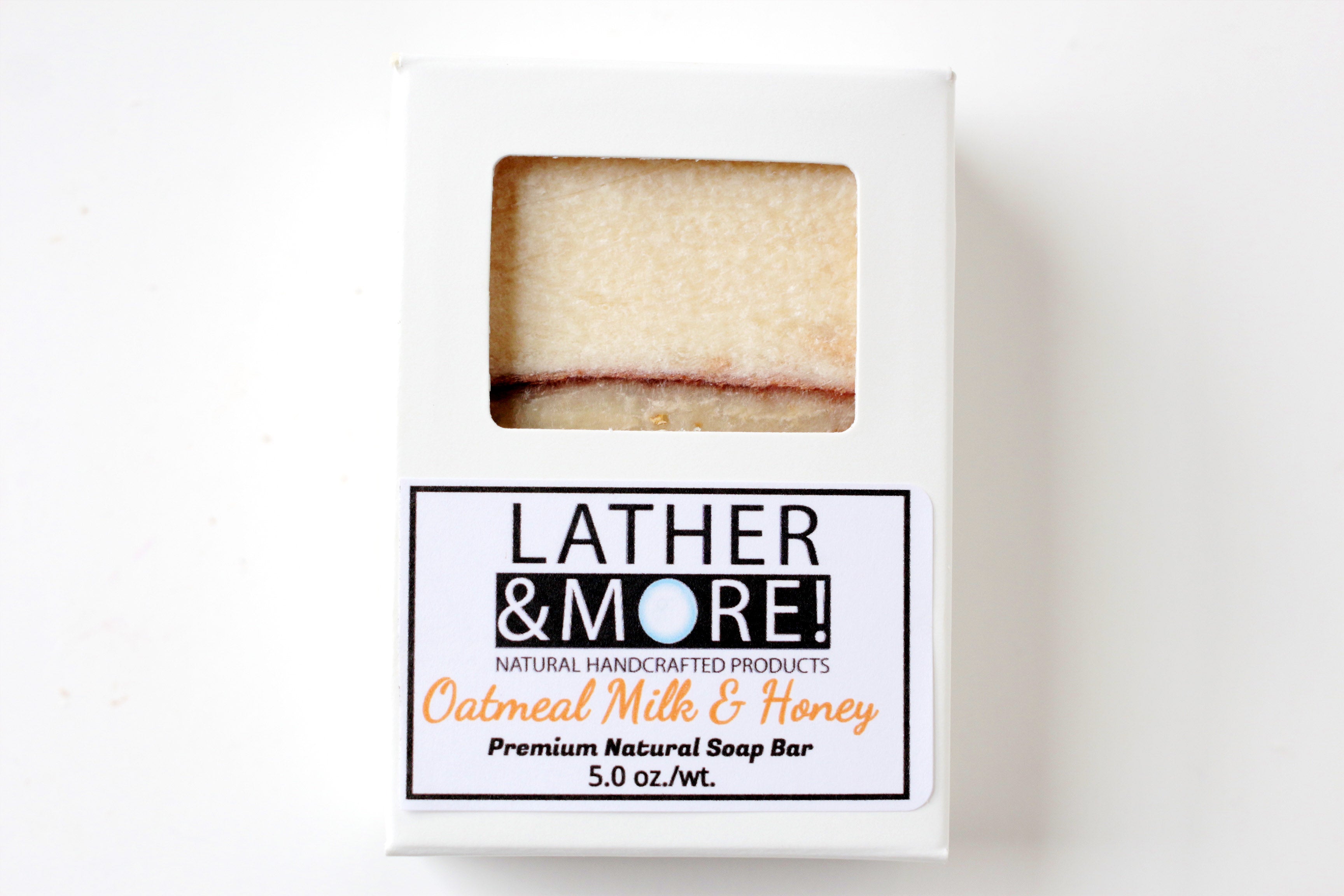 Oatmeal Milk and Honey soap inside of white soap box with window that shows texture of soap, white background.